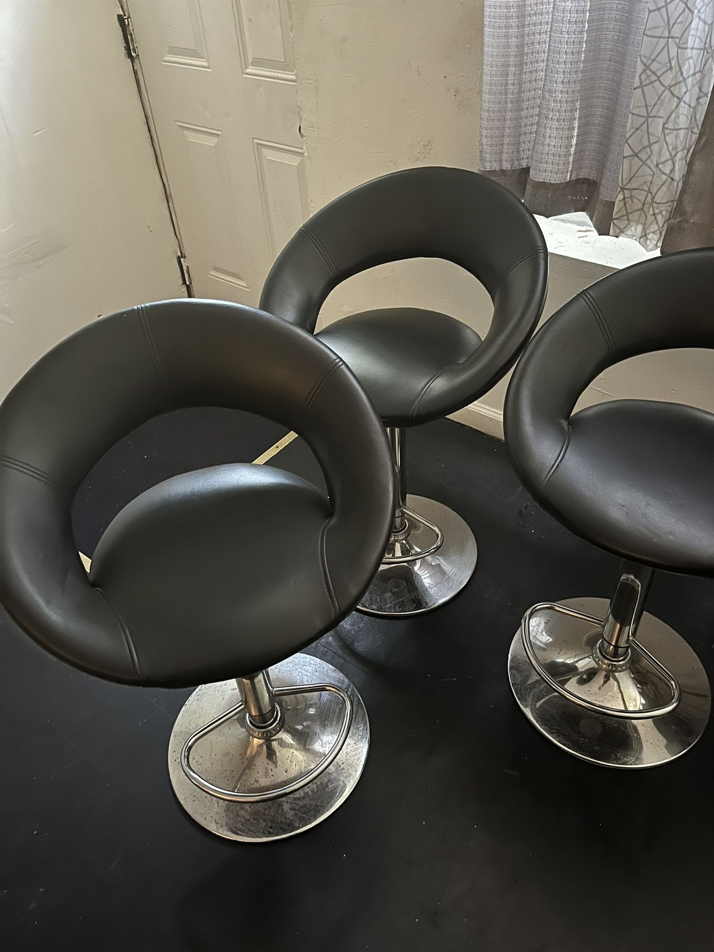 Three barstools a deep freezer dining room table with four chairs, a lamp