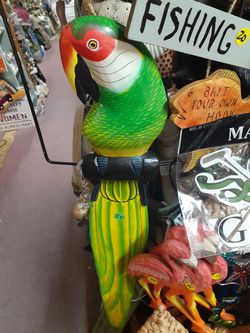 Large colorful wooden parrot on a swing