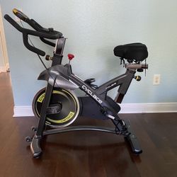 Cyclace Exercise Bike Stationary 330 Lbs Weight Capacity- Indoor Cycling Bike with Comfortable Seat Cushion, Tablet Holder and LCD Monitor