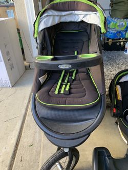 Stroller with car seat and base . Front tire flat .