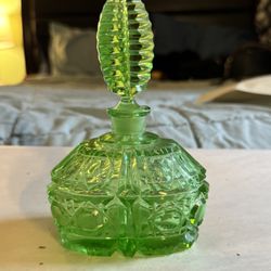 perfume bottle in the image is a vintage or antique Czech glass perfume bottle, likely made of vaseline glass or uranium glass.