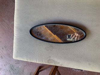 Black-framed oval mirror.