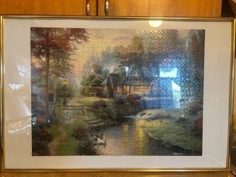 A framed puzzle and a vintage landscape print.