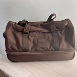 Calpak Stevyn Brown rolling duffel, a versatile blend of duffel bag functionality and wheeled luggage 22” 