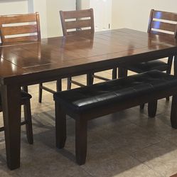 Crown Mark Bardstown table paired with upholstered side chairs and a dining bench.