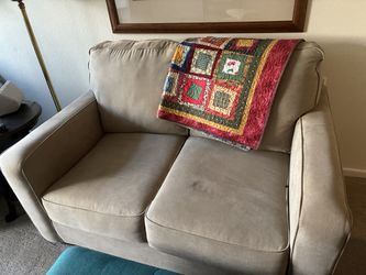 Beige loveseat sofa bed and blue recliner.
