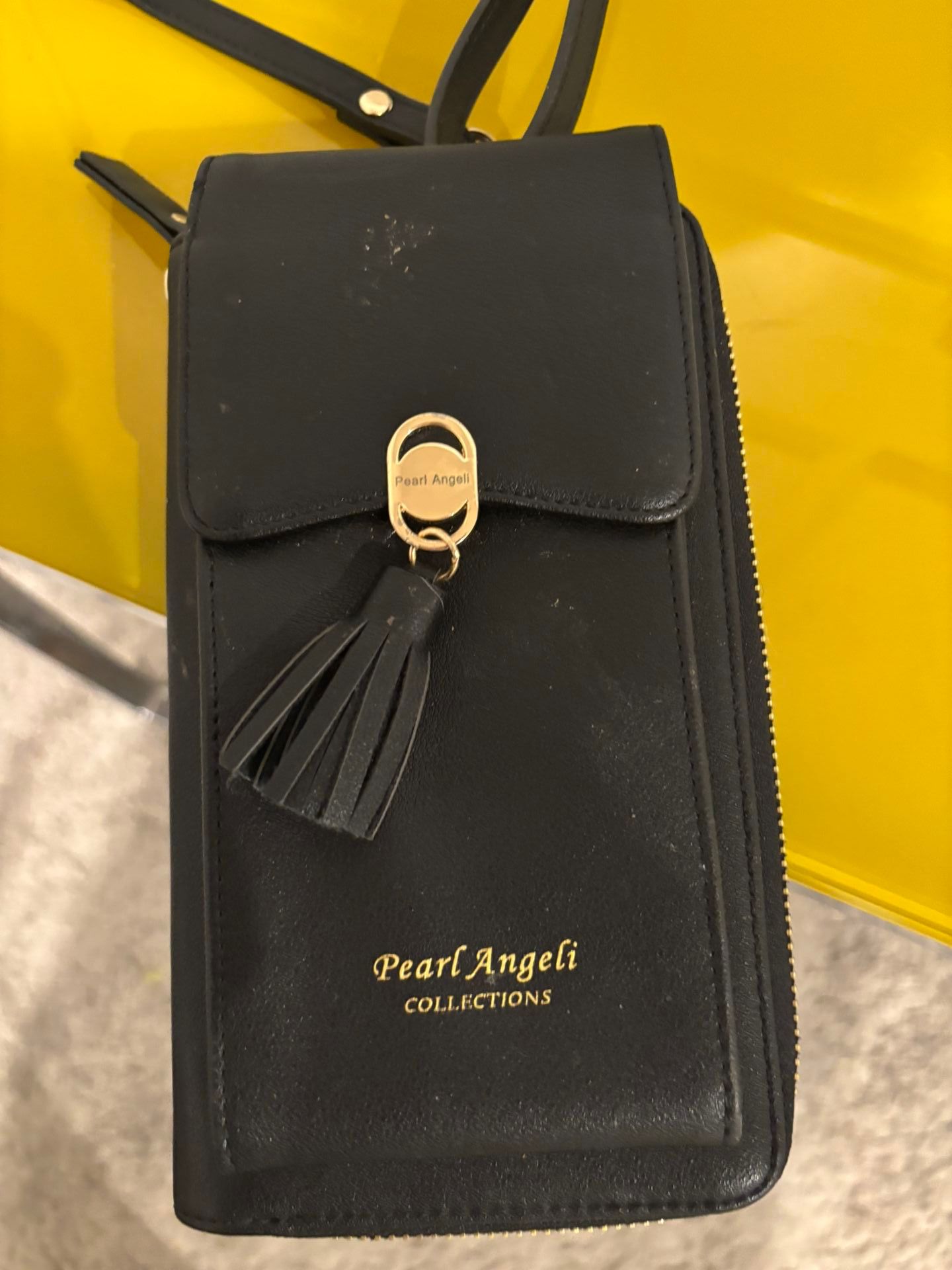 New black wallet that can be worn as a purse and it has a cell phone pocket as well
