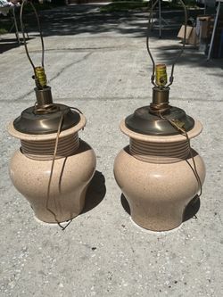 2 matching beige lamps w/o shades. 2nd photo shows slight chip on back of 1 lamp
