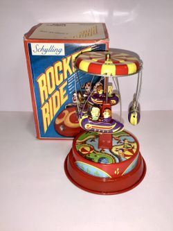 Vintage-style Schylling Rocket Ride tin wind-up toy from the Collector Series.  • Wind-up mechanism works • Bright colors, classic carnival / amusemen