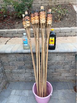 10 tiki torches and a couple of half bottles of tiki torch oil
