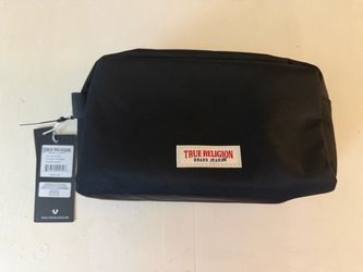 This is a True Religion "Anton" black travel toiletry bag featuring a signature logo patch and top-zip closure