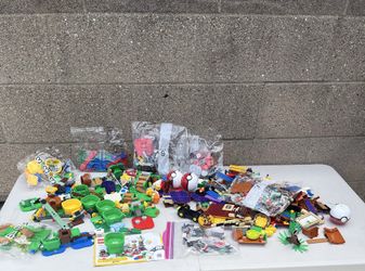 collection of various LEGO building components and sets, prominently including items from the LEGO Super Mario