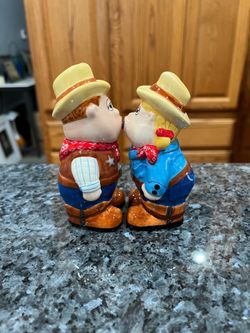 Ceramic Kissing Cowboy and Cowgirl Magnetic Kissing pair of salt and pepper shakers.  The lighting is bad no white spots on the shakers.  Size approxi