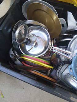 Tub full of pots pans with lids casserole dishes plates mix cutting bord