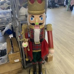 holiday nutcracker figurine featuring a king wearing a gold glitter crown and plaid attire