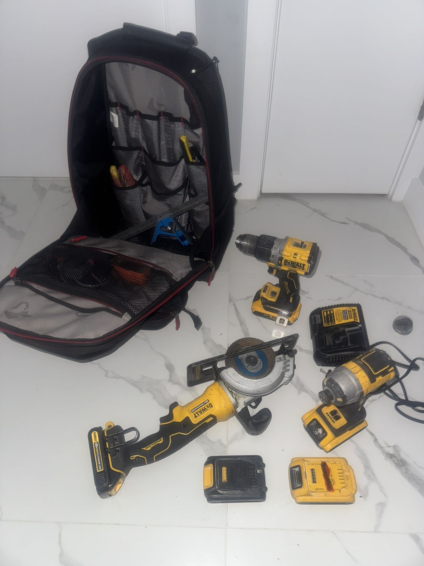 Dewalt package deal brushless grinder, three drills, five batteries, one charger, Husky, heavy duty book bag with levels, tools, measuring tape, eetc.