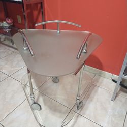Mesa mediana de cristal y ruedas..