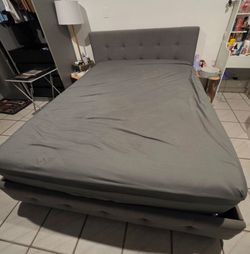 Gray queen-size bed with mattress