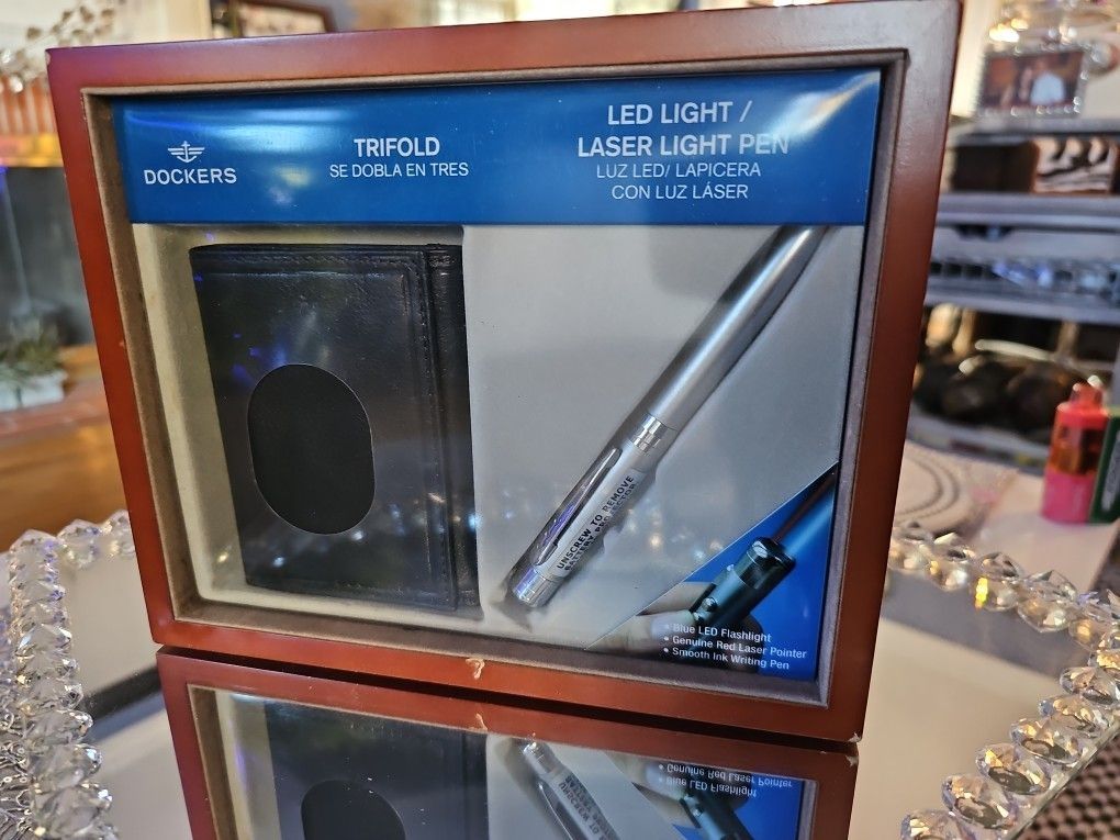 Neq In Package! Vintage, Dockers gift set featuring a black trifold wallet and a silver LED light/laser pointer pen.
Wallet is a trifold. In Wooden Bo