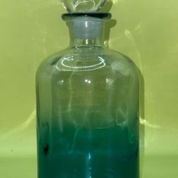 Blue ombré glass bottle decanter with a glass ball stopper.