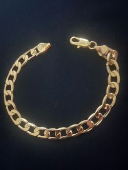 Elegant 24 K Gold Curb Link Bracelet with a secure lobster claw clasp. This piece has a polished finish and a classic flat link design.