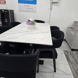 Dining room with 6 black chairs, white table. 