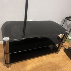 Steel and Glass TV Stand with a black tempered glass chrome-effect legs. Entertainment center