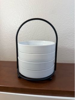 set of 4 white ceramic round appetizer plates placed on a metal holder