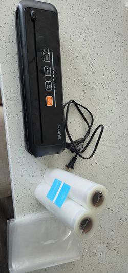 black KOIOS vacuum sealer machine accompanied by two rolls of vacuum sealer bags.