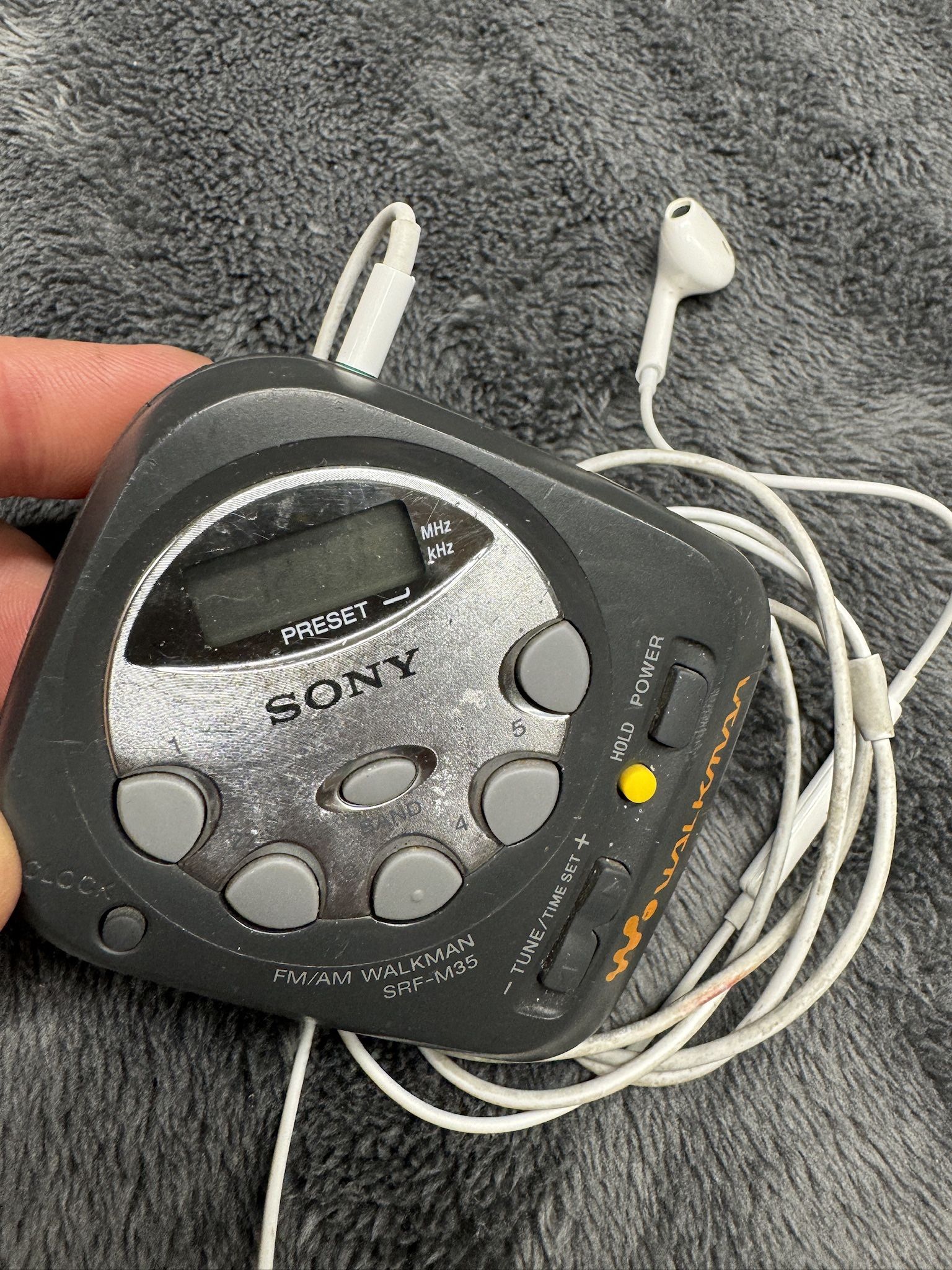 Vintage Compact Sony Am/FM Walkman with Apple Earpods w/Mic. Works great! Runs on Two AAA.