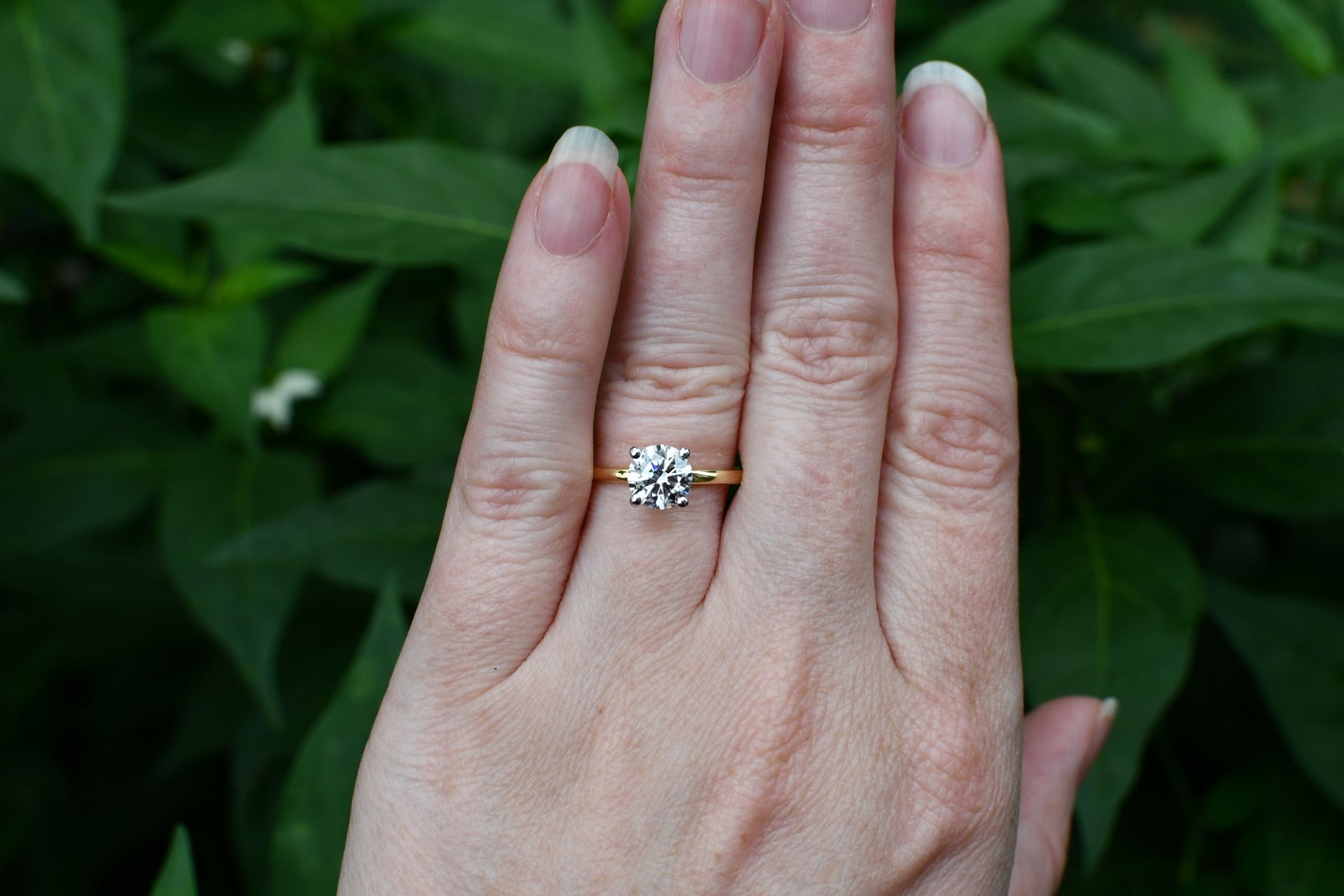 1.05 CT lab-grown round solitaire engagement ring in 14K yellow gold with white gold prong tips. Includes IGI report.