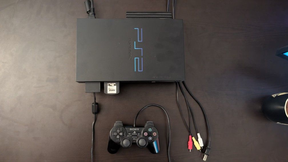 PlayStation 2 (PS2) console, controller, cables, and games