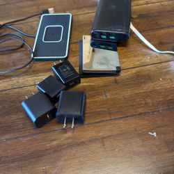 Two Charging Banks One Is A Halo, A Wireless Charging Pad And Some Usb Plug-In Adapters