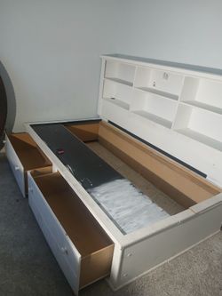 Twin bed with book case.