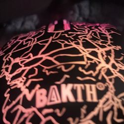 This is a BAKTH wired gaming mouse with an ergonomic design and a cracked LED pattern.