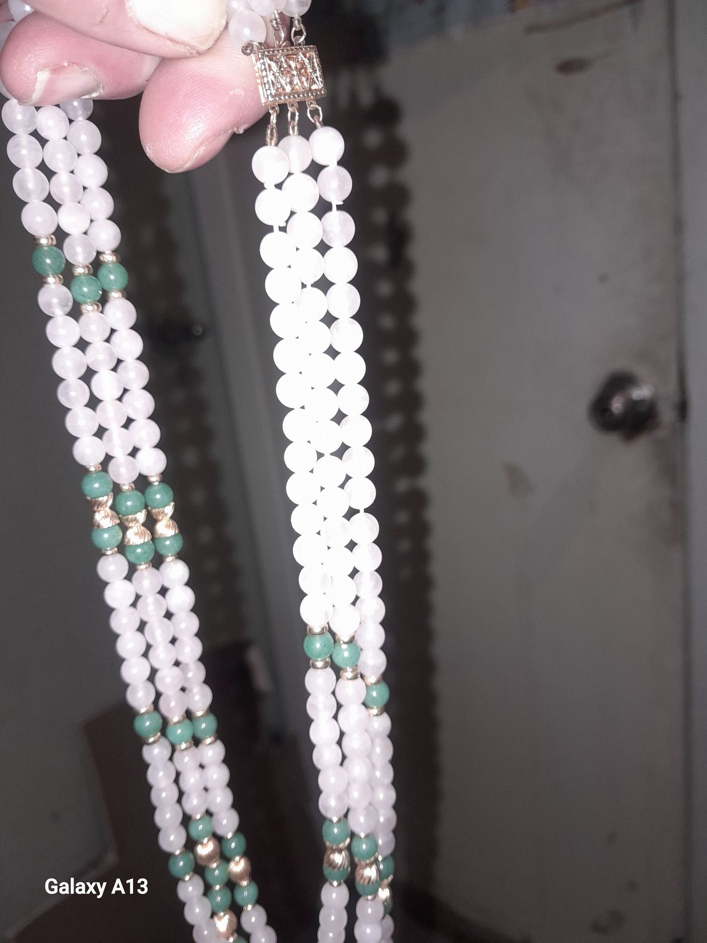 Three strand necklace made out of 14 karat gold beads with Jade and coral beads