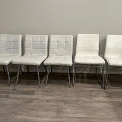 5 White Faux Leather Chairs.
They are of 2 different styles.