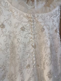 Oleg Cassini White bead embroidered wedding dress Size 10 Ivory mermaid style with a sweetheart neckline

Condition is used with a couple small tears 