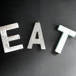 “EAT” set of rustic, multicolored wooden letters