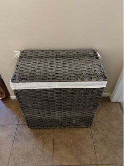 woven resin laundry hamper with a hinged lid and removable fabric liner.