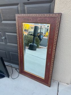 large rectangular wall mirror featuring an ornate burgundy and gold-trimmed wooden frame with a classic Greek key geometric border