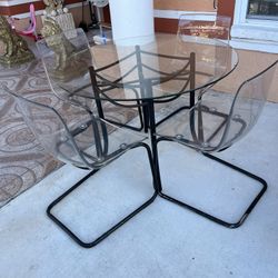 Dining set with 4 chairs. See details of the chair; it has a crack but is insignificant. Strong plastic and metal. Round table with glass measures 42 