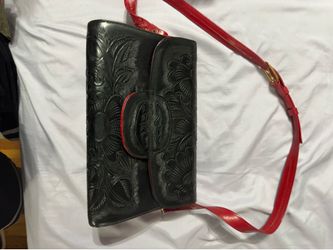 Vintage Mexican convertible purse features intricate hand-tooled floral patterns on black leather and a contrasting red leather strap
