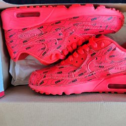 Nike Air Max 90 Premium 'Just Do It' sneakers, featuring a bright crimson red upper covered in "Air Max" branding