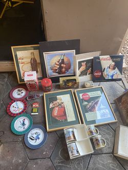 I am selling 19 Coca-Cola collectible pieces, including a Coca-Cola blanket and various framed items. I am asking for $60 for everything, firm price.
