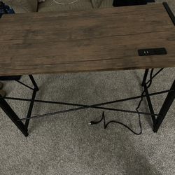Writing or computer desk with a built-in power strip with AC and USB outlets