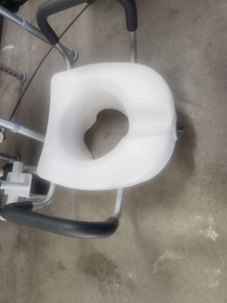 Raised toilet seat with lock and arms
