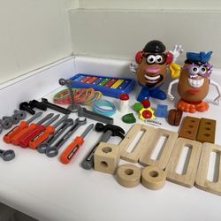 Toy set with Mr. Potato Head figures, xylophone, toy tools, and wooden blocks.