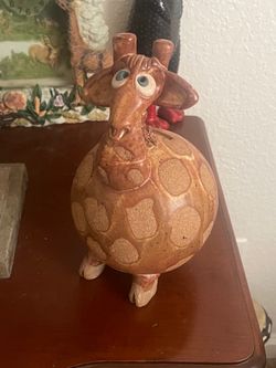 Clay giraffe figurine coin bank