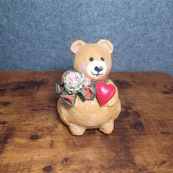 whimsical teddy bear clutching a bright red heart